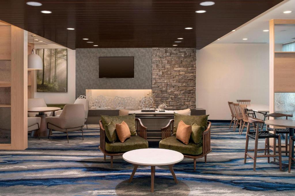 迈阿密Fairfield Inn & Suites by Marriott Miami Airport West/Doral的大堂设有桌椅和电视。