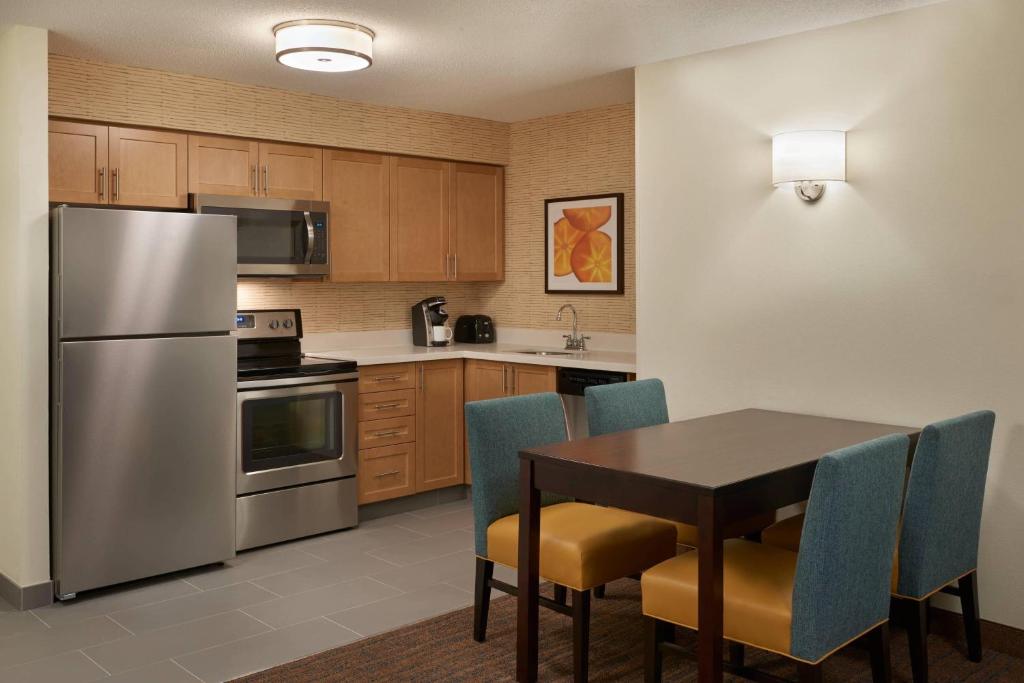 多伦多多伦多机场万豪原住客栈的厨房配有桌子和不锈钢冰箱。