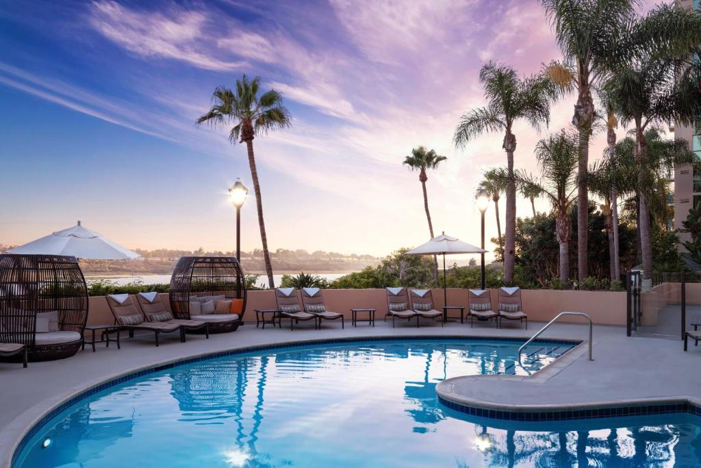 纽波特海滩纽波特海滩万豪湾景酒店的一个带椅子的游泳池,棕榈树