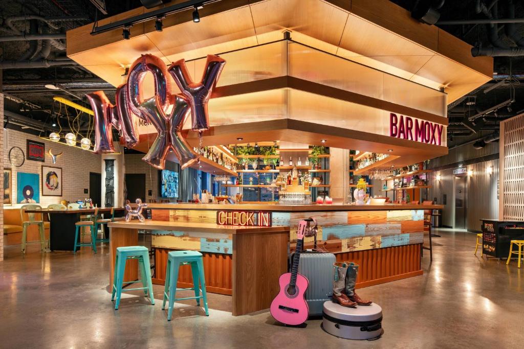 奥斯汀Moxy Austin - University的餐厅设有酒吧,提供两把吉他和两张凳子