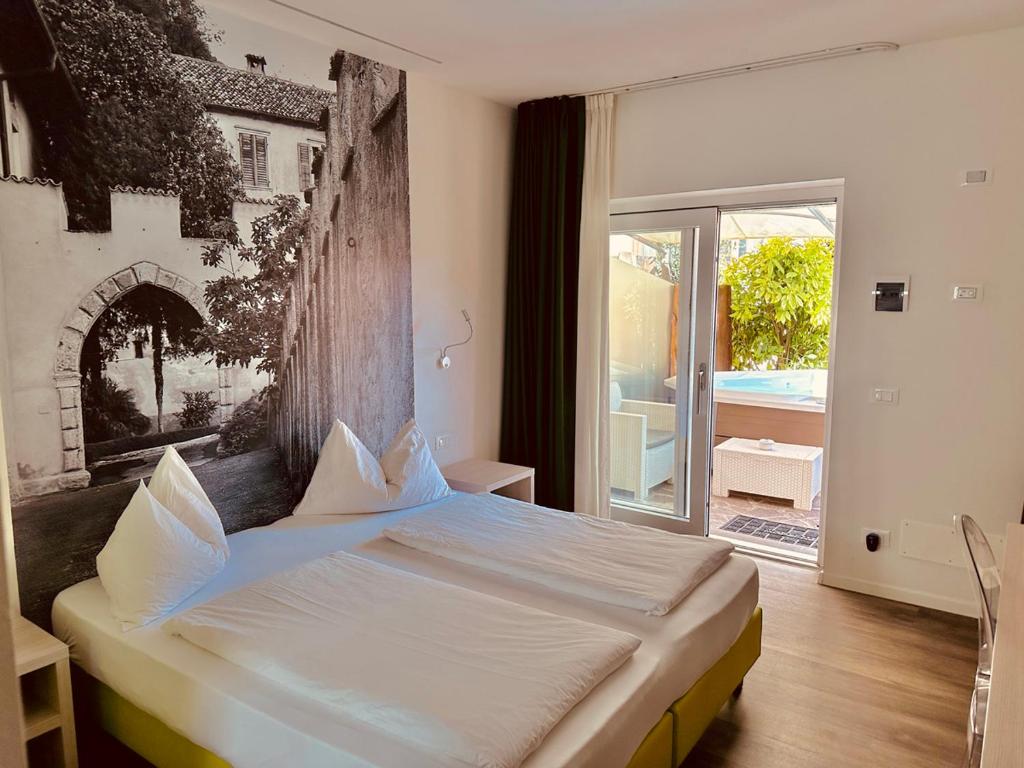 梅佐隆巴尔多CASA da CARMEN - Relax & Tradizione的一间卧室设有一张床和一个大窗户