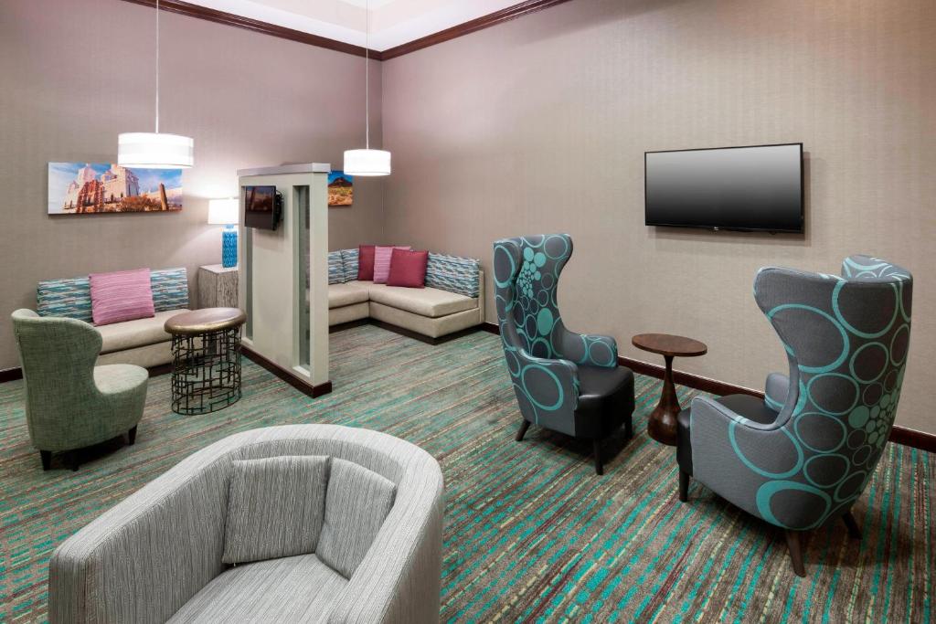 土桑图森机场原住客栈的客厅配有沙发、椅子和电视