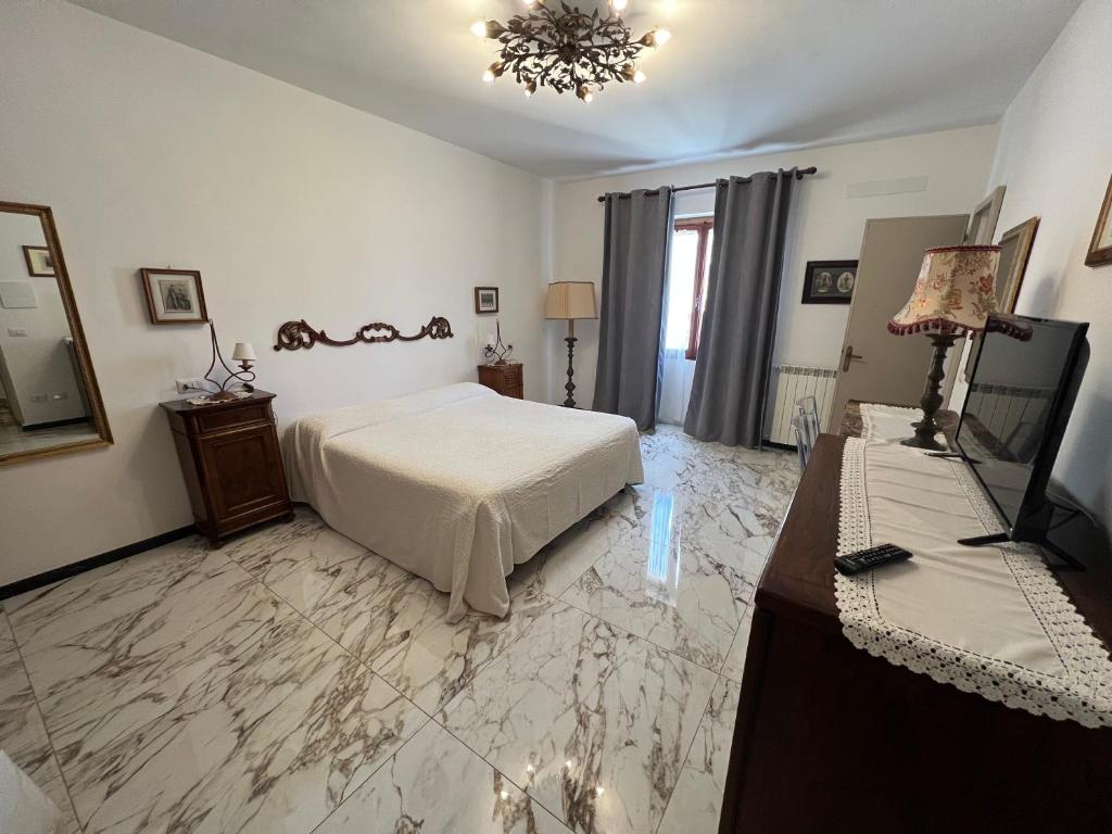 萨杜勒尼亚Le Camere dei Magi的一间卧室配有一张床、一张桌子和一台电视