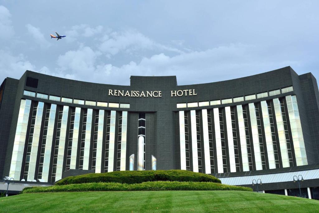 圣路易斯文艺复兴圣路易斯机场酒店 的一座大型建筑,有飞机在空中飞行