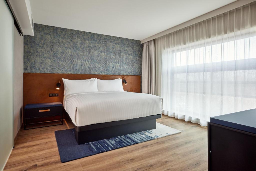 斯特拉斯堡Residence Inn by Marriott Strasbourg的一间卧室设有一张床和一个大窗户