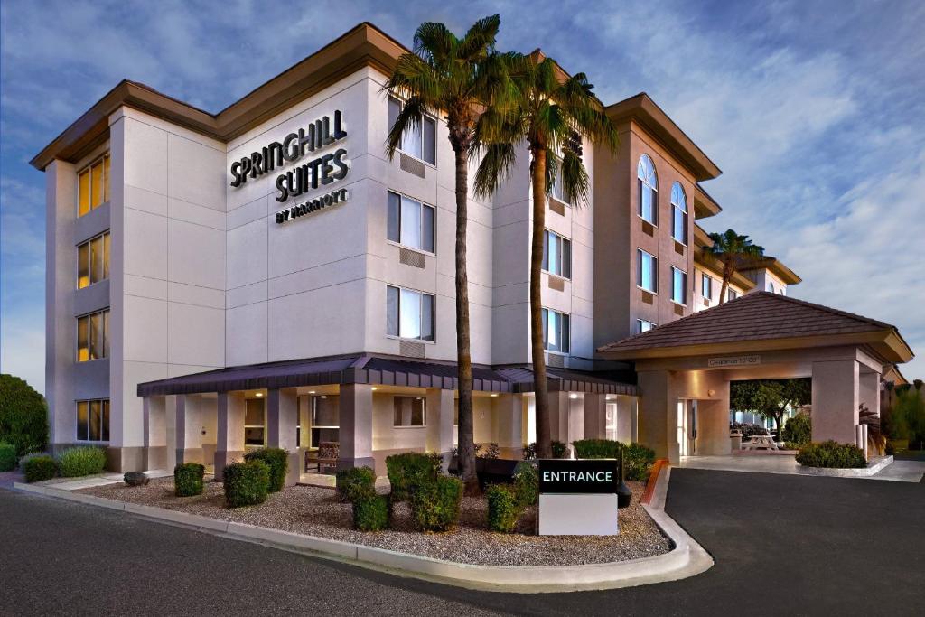皮奥里亚凤凰城格伦代尔/皮奥里亚春季山丘套房酒店的一座建筑前有棕榈树的酒店
