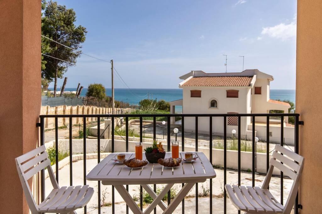 诺托玛丽娜~ Villa Demetra ~的阳台配有一张桌子和两把椅子,享有海景