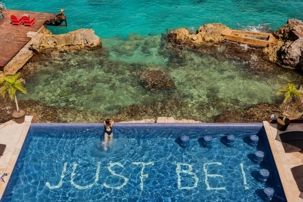 科苏梅尔Hotel B Cozumel的站在游泳池里的女人,说的话只是
