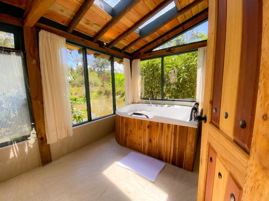 莱瓦镇Suite Cabaña Cantodeagua-Jacuzzi的一间带浴缸的浴室,位于带窗户的客房内