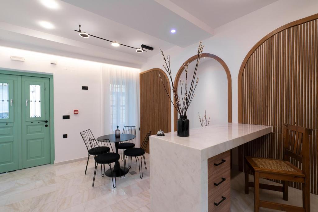 海若克利欧Sartori Concept Hotel的厨房配有桌椅和绿门。