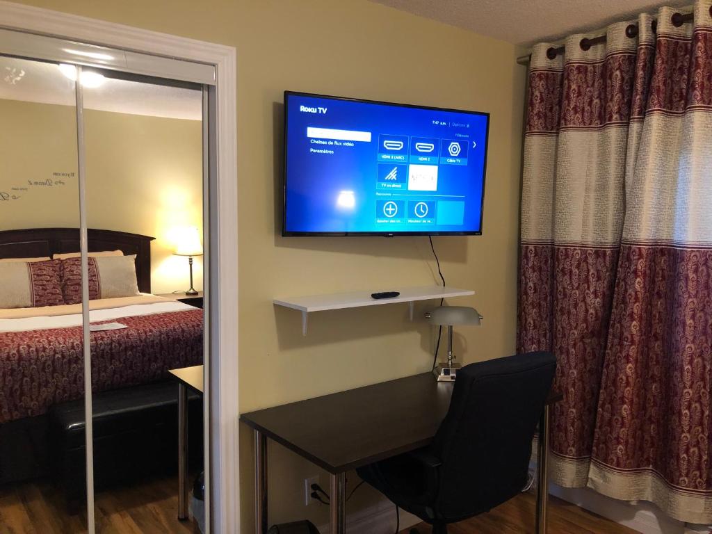 BeresfordMotel 7 Inn & Suites的酒店客房设有一张桌子和一台墙上的电视。