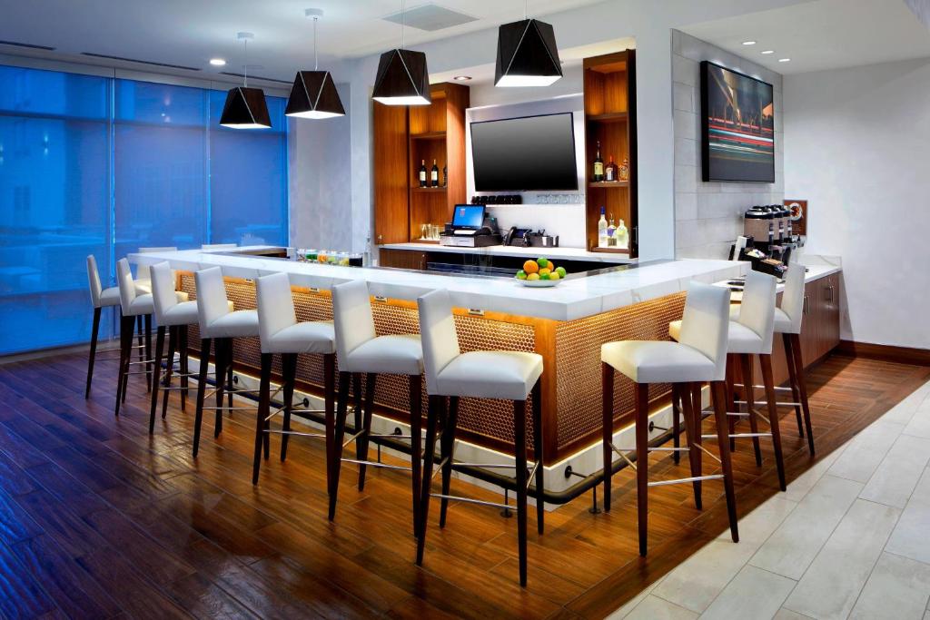 哥伦布SpringHill Suites by Marriott Columbus Easton Area的厨房设有带白色凳子的酒吧