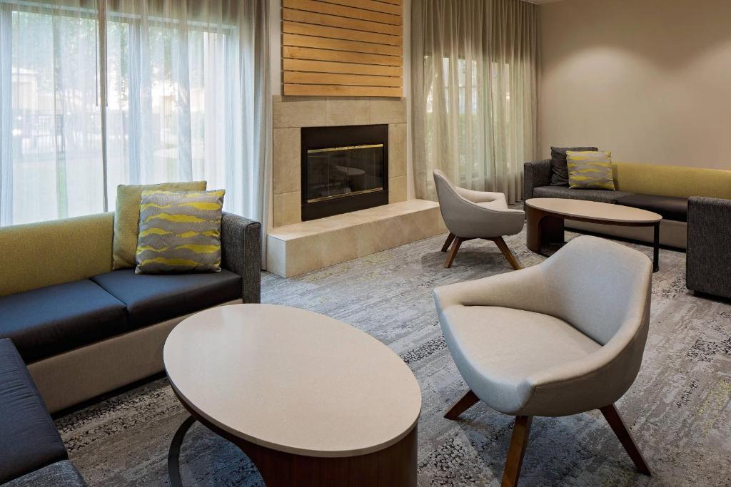休斯顿休斯顿威斯特契斯万怡酒店的带沙发和桌子的客厅以及壁炉。