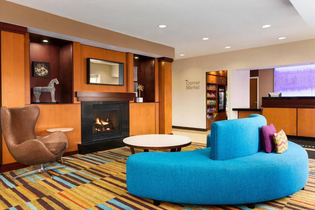 莫米托莱多茂美费尔菲尔德酒店 - 万豪集团旗下酒店的客厅设有蓝椅和壁炉