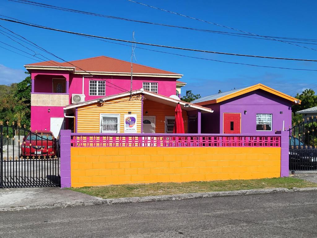 OsbournTequila Sunrise Antigua的一座色彩缤纷的房屋,前面设有围栏