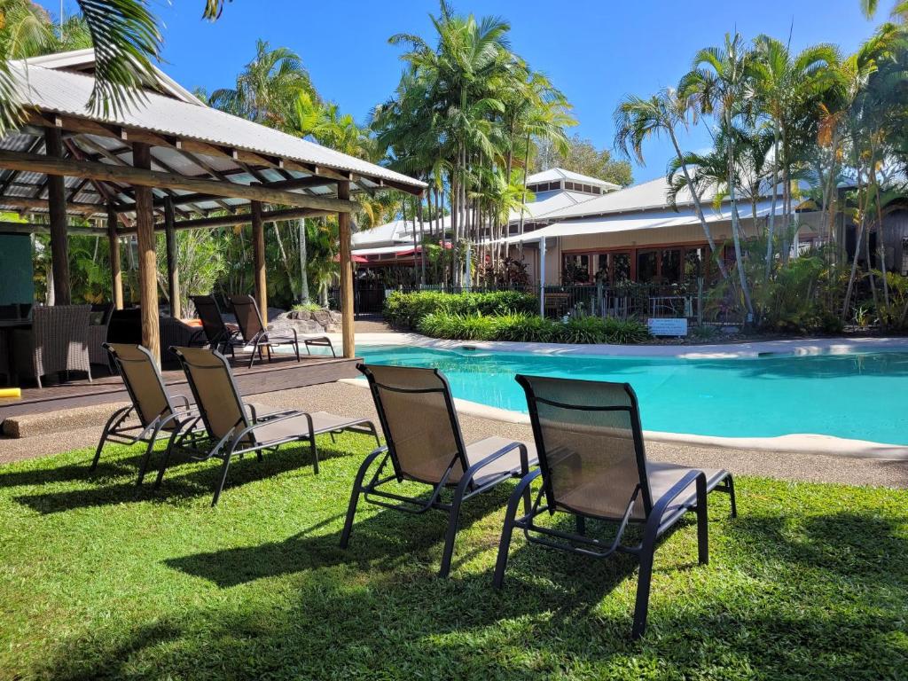 努萨维尔努沙南太平洋度假酒店&Spa的一群坐在草地上的游泳池边的椅子