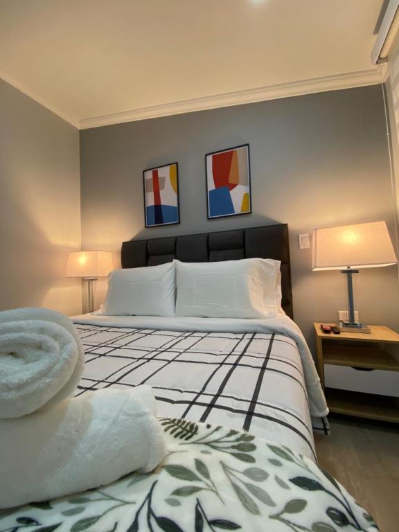 波哥大Cal Bed & Breakfast的一间卧室配有一张大床,墙上有两幅画作