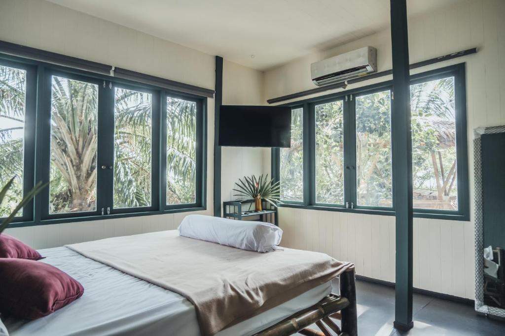 Ban NokLeela Garden Resort的一间卧室配有带窗户的床和空调