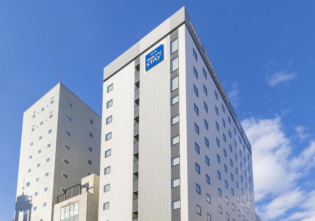 札幌札幌大通东急STAY酒店的上面有蓝色标志的高大的白色建筑