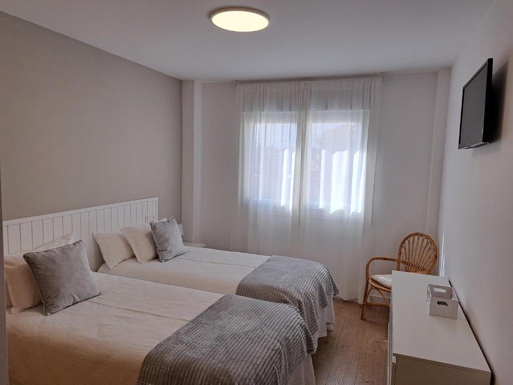 桑亨霍Apartamento Calvarios的酒店客房设有两张床和窗户。