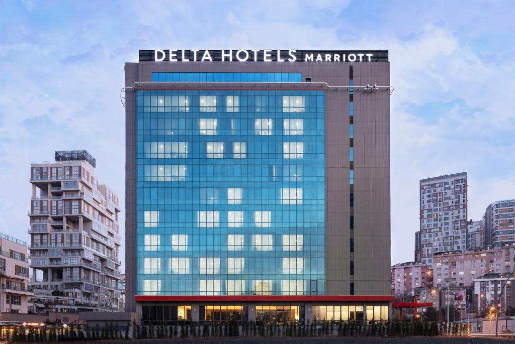 伊斯坦布尔Delta Hotels by Marriott Istanbul Kagithane的一座高大的建筑,上面有标志