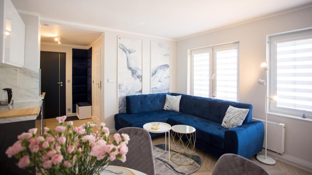 乌斯特卡Apartamenty Sun & Snow Stare Miasto Ustka的客厅配有蓝色的沙发和桌子