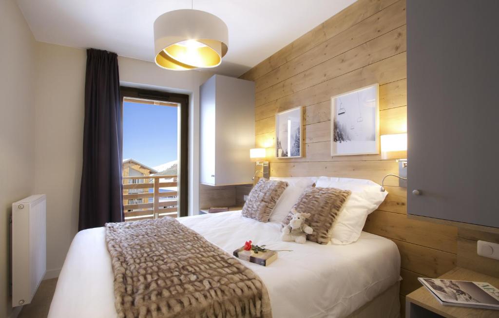 拉普德兹Résidence Prestige Odalys l'Éclose的卧室配有一张大白色床和窗户