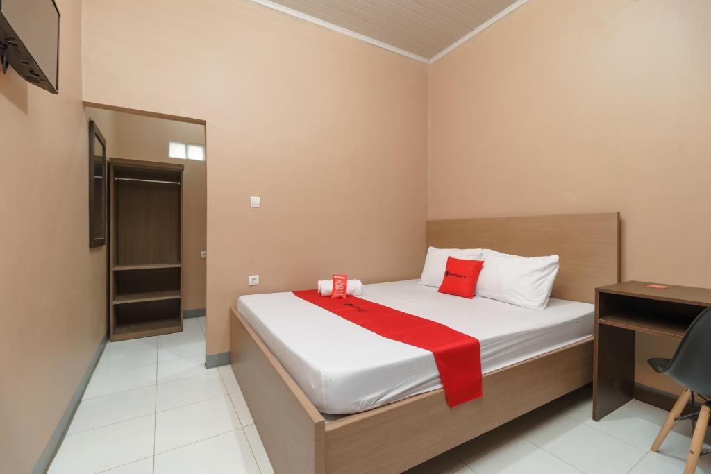 贝克西RedDoorz Syariah @ Bulak Kapal的一间卧室配有一张床铺,床上铺有红色毯子
