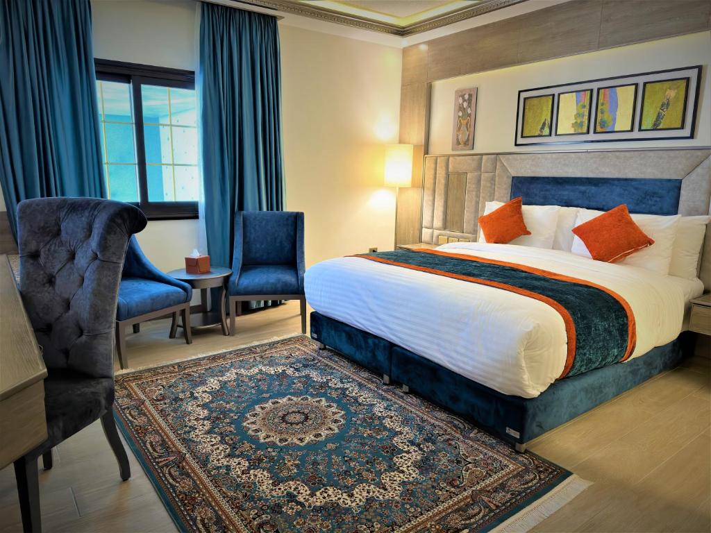 瓦迪穆萨Petra Canyon Hotel的酒店客房,配有一张床、一张桌子和椅子