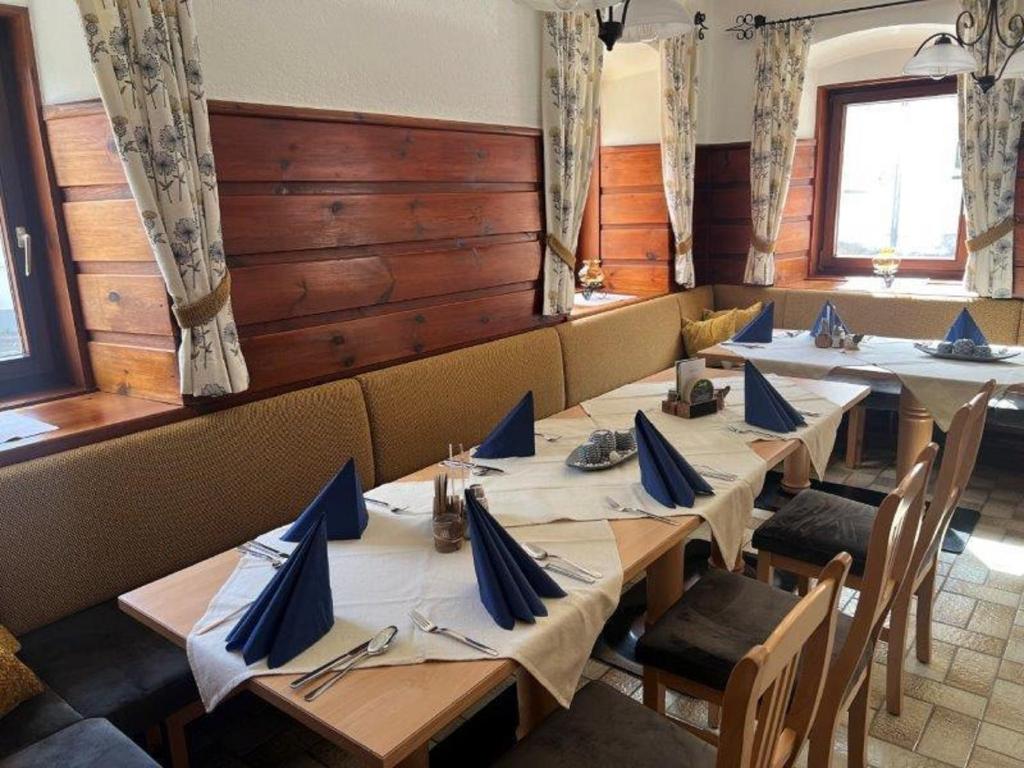 伊布斯河畔格施特灵Gasthof Kögerlwirt的蓝色餐巾的餐厅的一排桌子