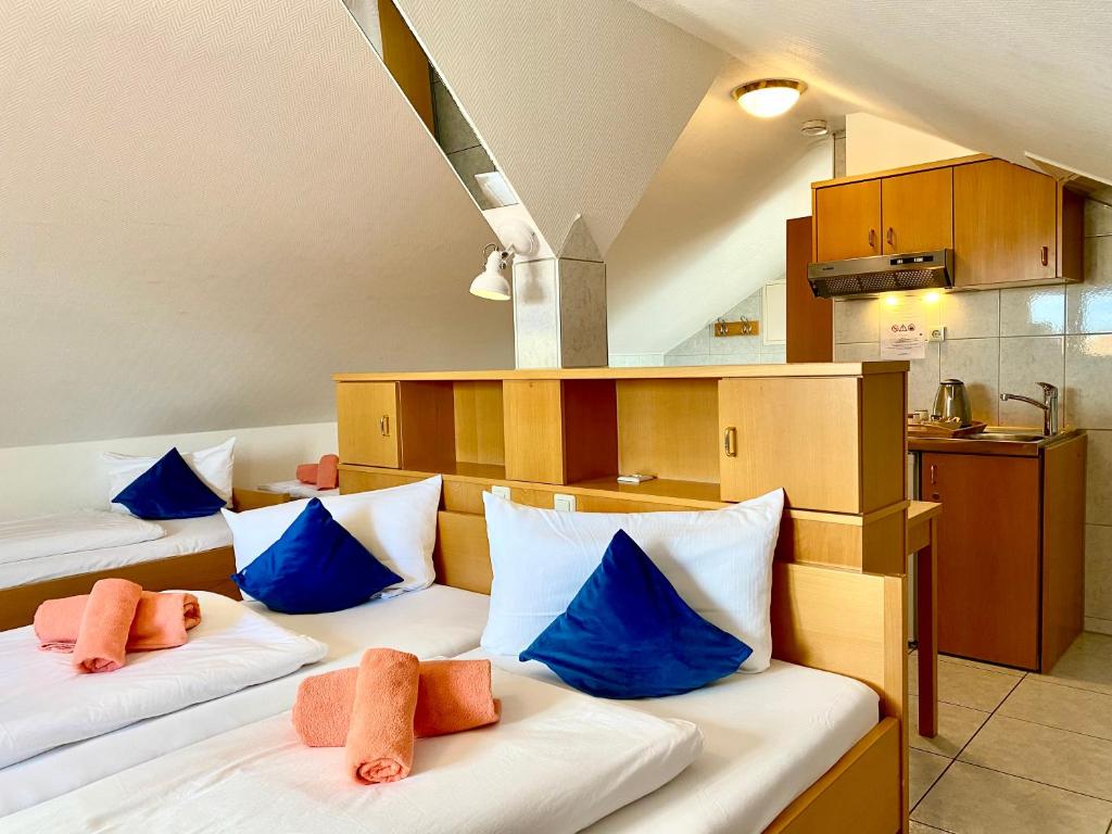 斯图加特M酒店的客房配有两张带蓝色枕头的床。