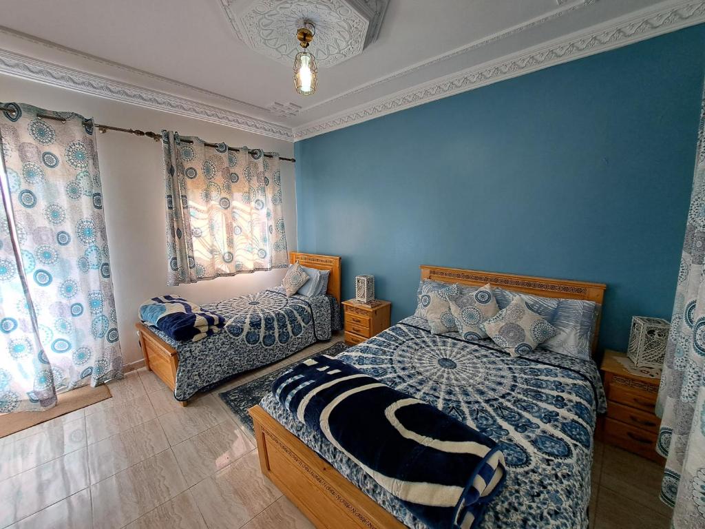 丹吉尔Diafa的一间卧室设有两张床,拥有蓝色的墙壁。