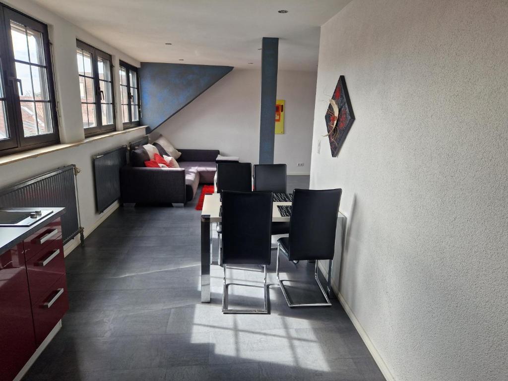 施派尔Wohnen auf Zeit City Speyer的客厅配有桌子和黑椅子