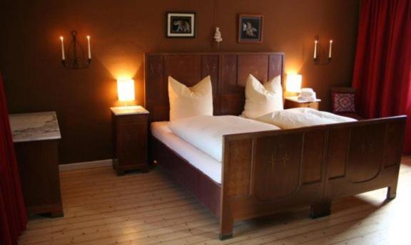 克分楞麦穆勒尔酿酒厂旅馆的一间卧室配有一张带两盏灯的大木床。