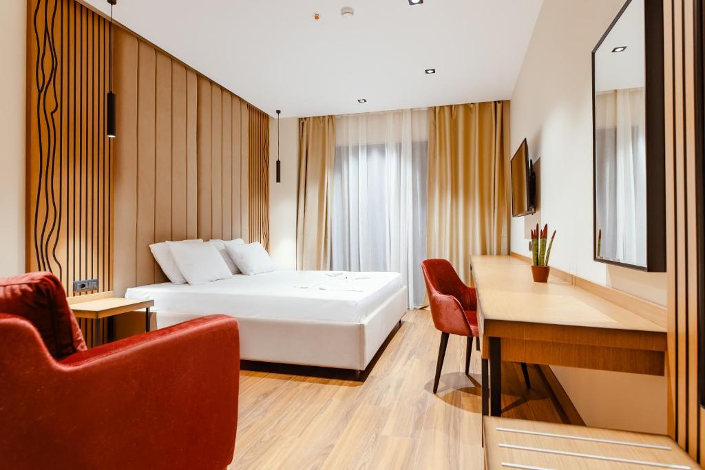 伏罗拉Valza Boutique Hotel的配有一张床和一张书桌的酒店客房