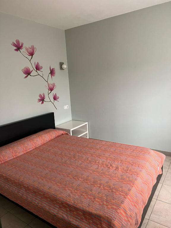 韦斯卡Hostal - Restaurante Asador Esperanza的卧室配有一张挂着鲜花的床