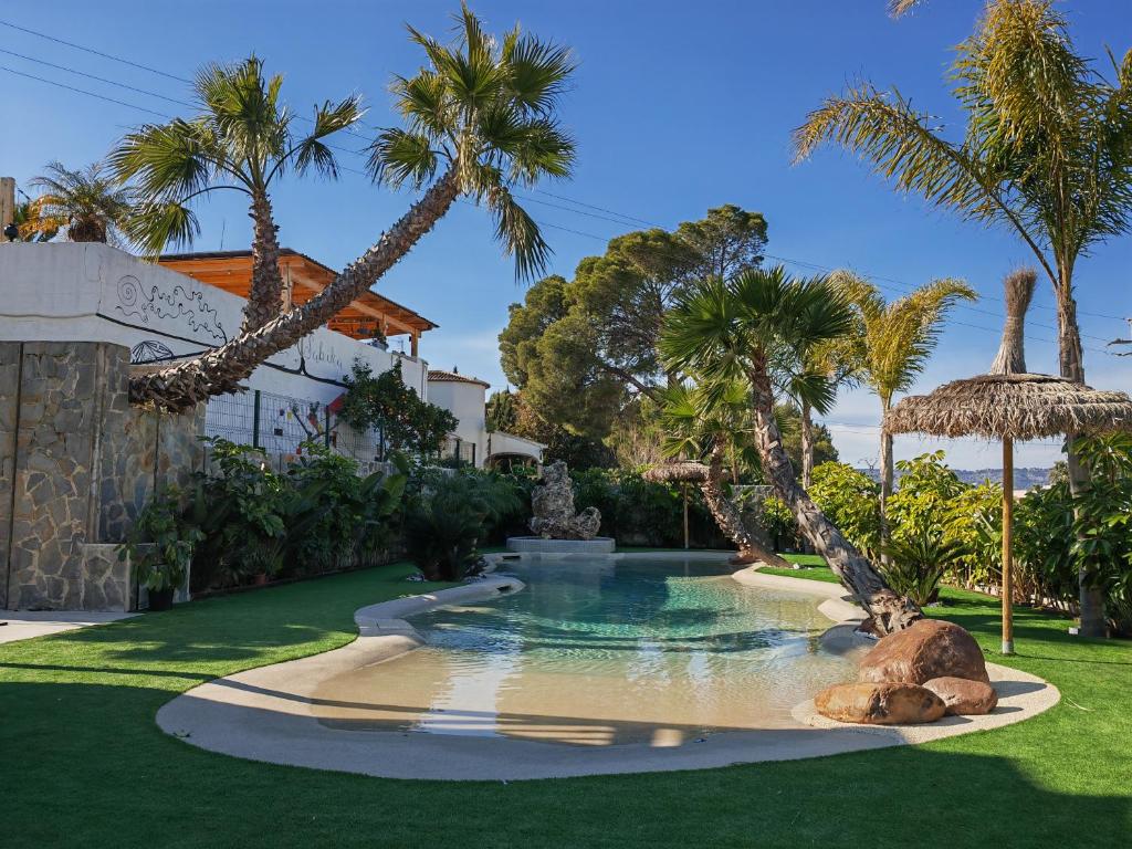 哈维亚Hotel Casa Lili的棕榈树庭院内的游泳池