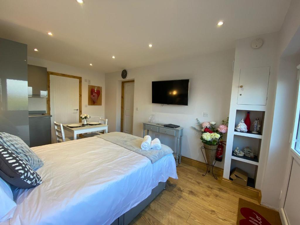 彭里斯Beautiful 1-Bed studio in Penrith的一间带白色大床的卧室和一间厨房