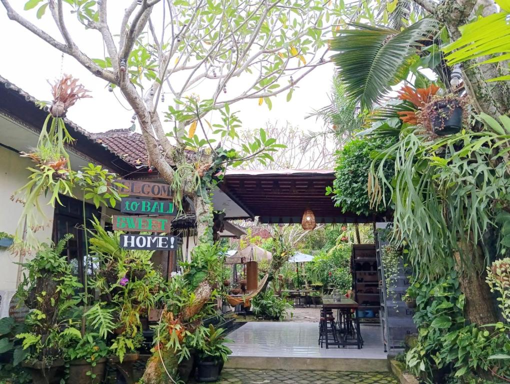 塔巴南Coliving Bali SWEET HOME Kost Lengkap di Tabanan Kota的花店,带有标志和一些植物