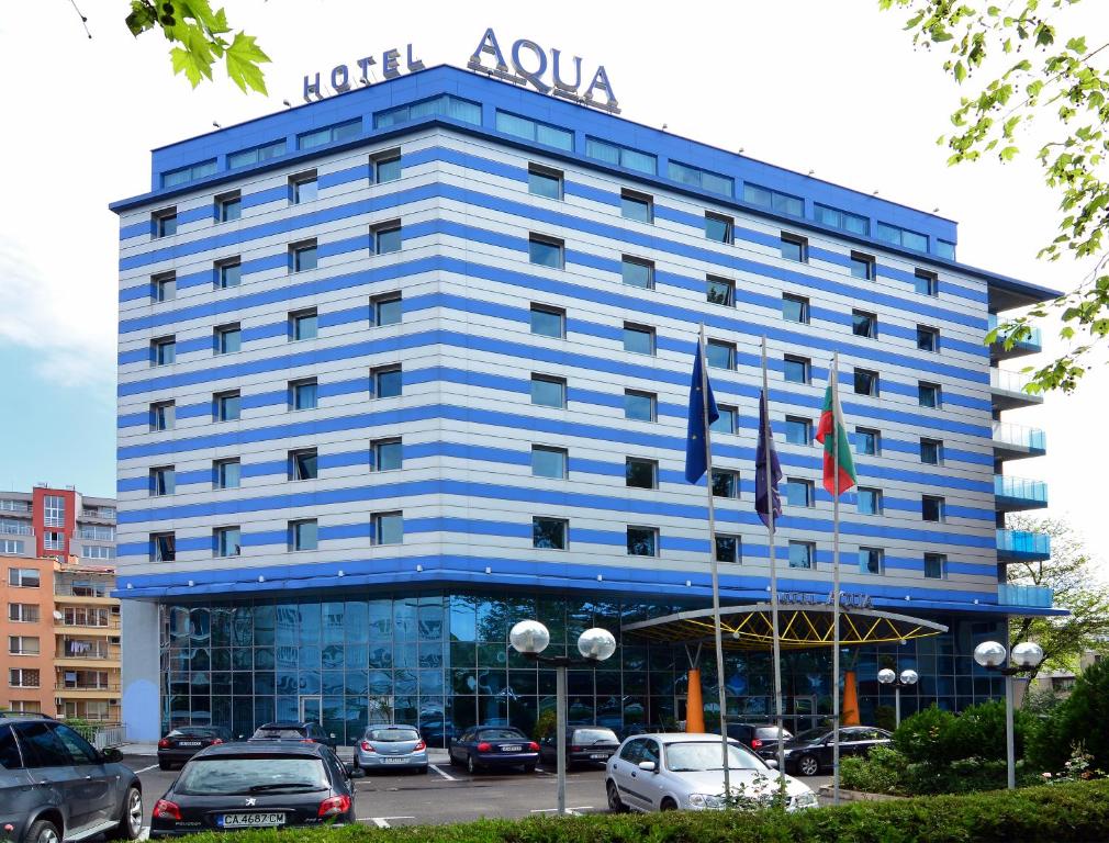 布尔加斯水族酒店的蓝色的酒店大楼,停车场有车辆停放
