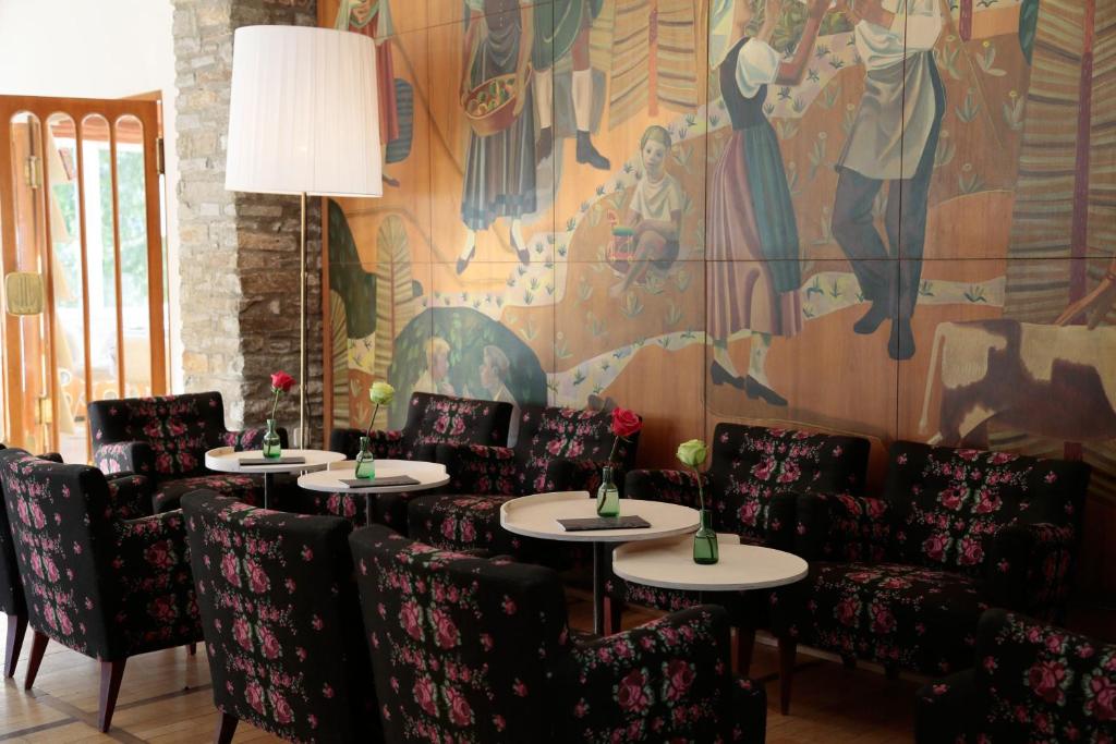巴德加斯坦Design Hotel Miramonte的用餐室配有桌椅和壁画