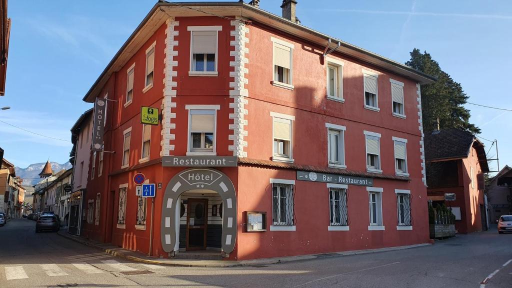 YenneLogis Hôtel du Fer à Cheval的街道边的红色建筑