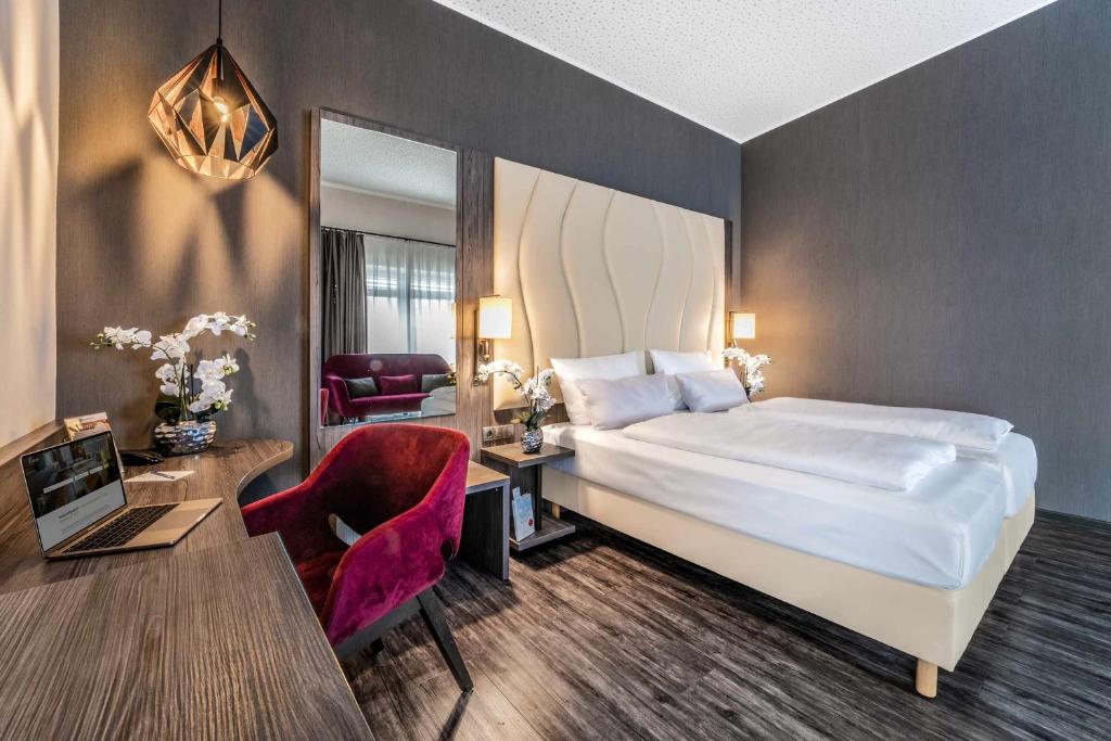 海尔布隆卡斯特尔最佳西方酒店的酒店客房配有一张床、一张桌子和一把椅子。
