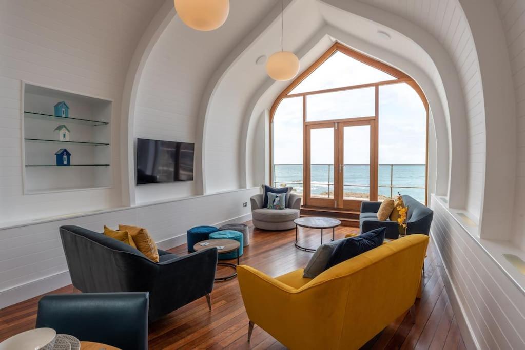伊尔弗勒科姆Ultimate Harbourside的客厅配有椅子和大窗户