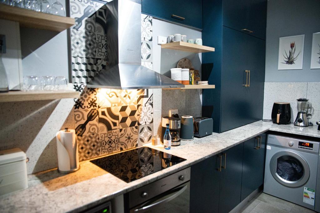 彼得马里茨堡Mdumela Stays 2 Bedroom Modern City Apartment的厨房配有蓝色橱柜和炉灶烤箱。