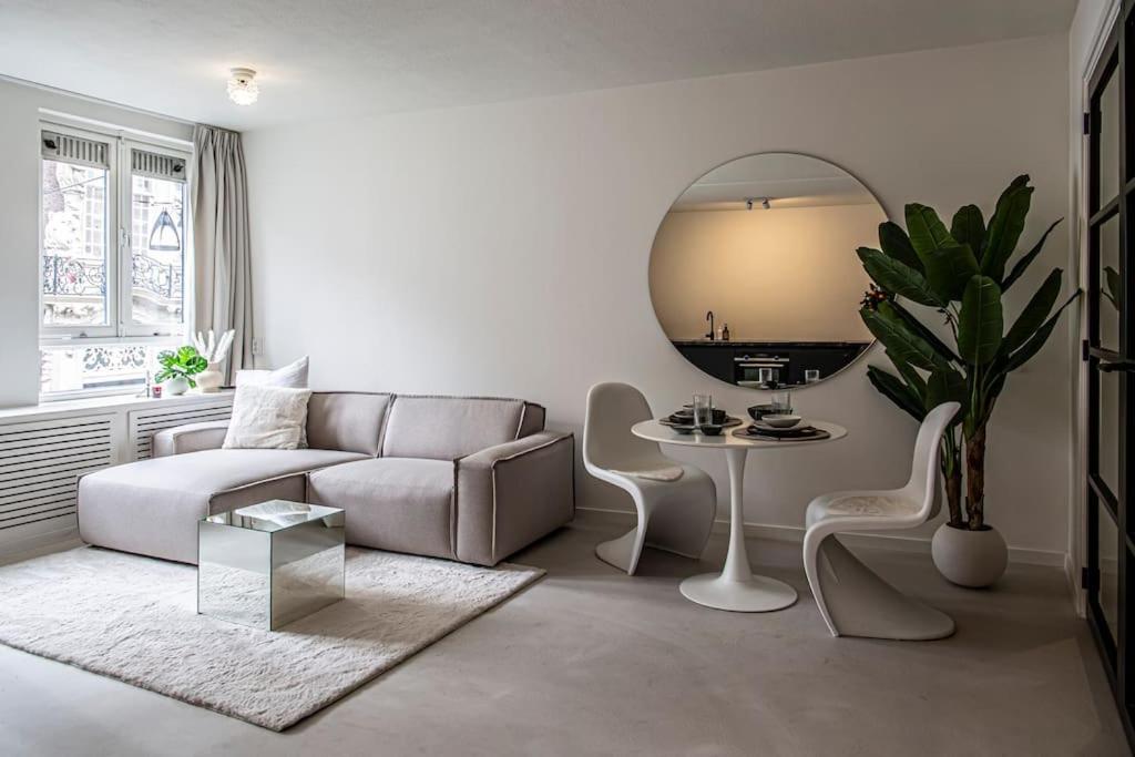 多德雷赫特Cloud Nine - romantic & design app in city center!的带沙发、桌子和镜子的客厅