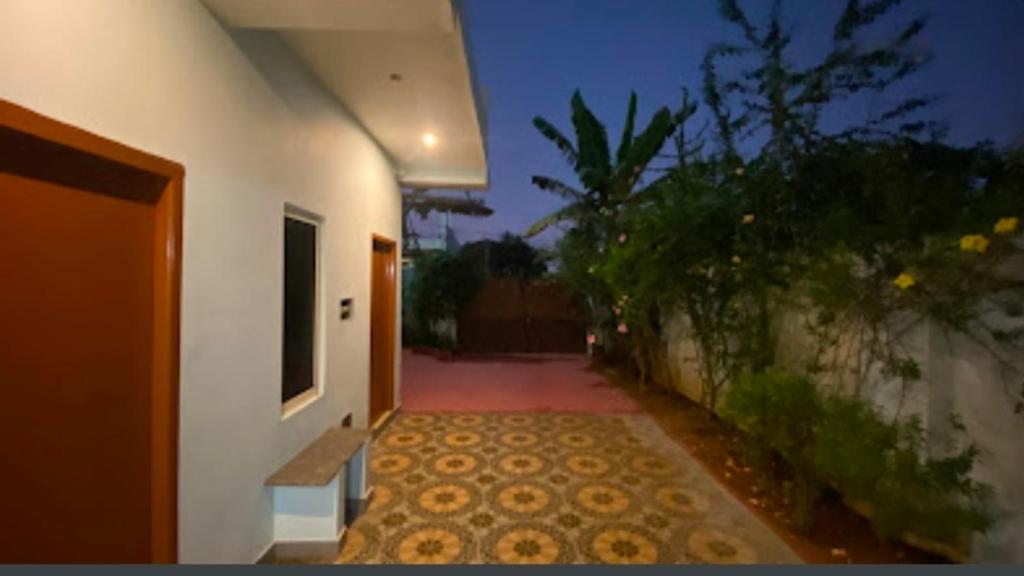 VānūrFamily Guest House Pondicherry的一条白色建筑的走廊,有一条走道