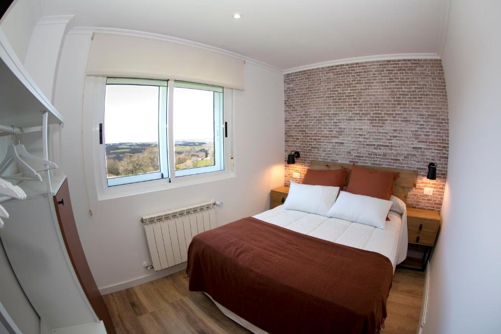 阿丰萨格拉达卡萨马诺洛旅馆的一间卧室设有一张床和砖墙