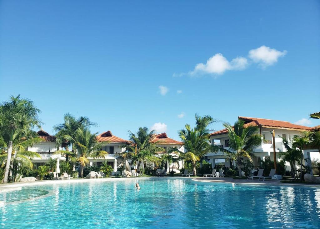 巴亚希贝Residencial Paraiso Bayahibe的棕榈树和别墅度假村的游泳池