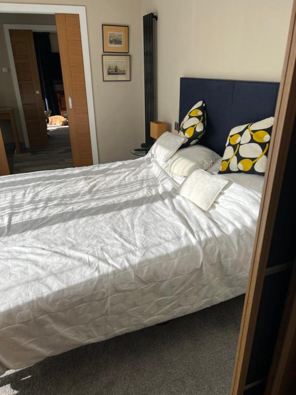 莱普斯通Sea breeze Exmouth的一张带白色床单和枕头的床